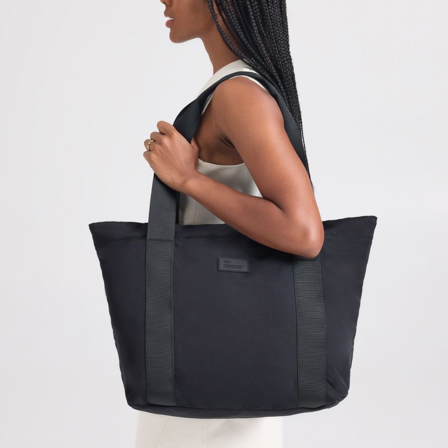 The included packable travel tote worn over the shoulder