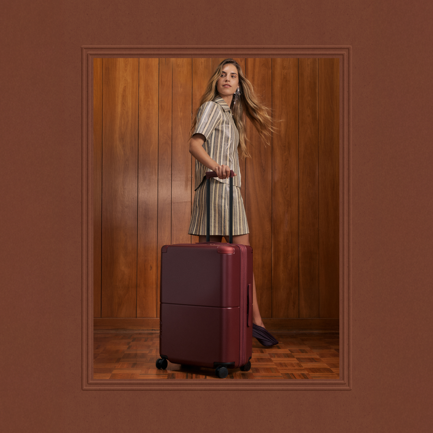 Woman with a burgundy July suitcase, framed