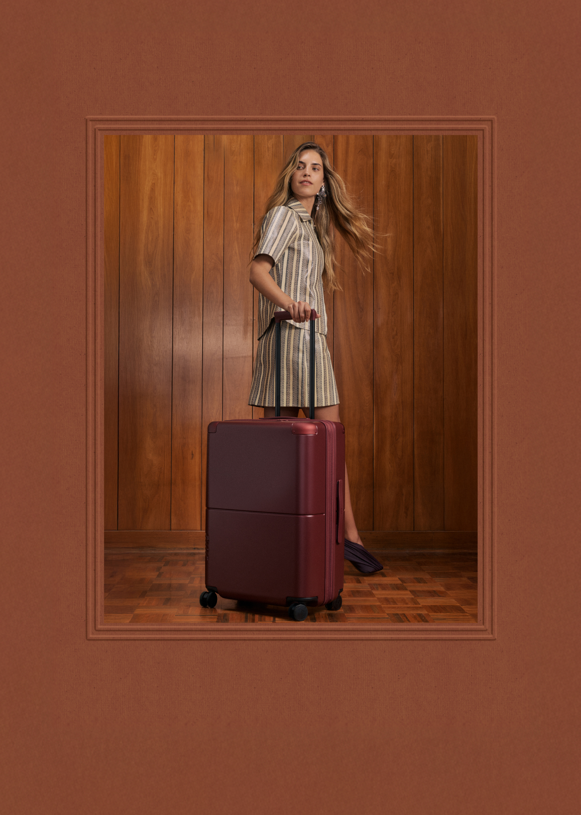 Woman with a burgundy July suitcase, framed