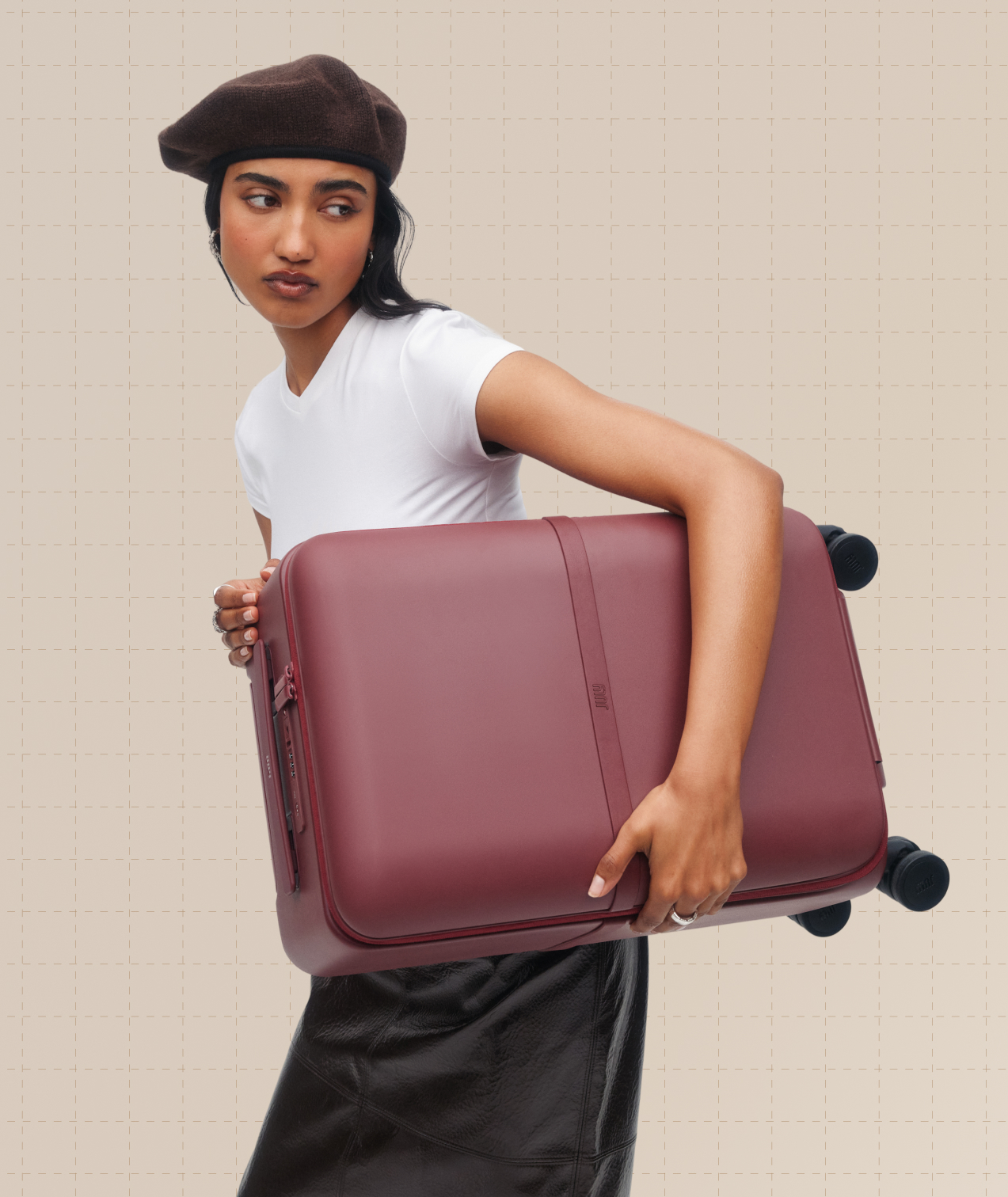 Woman carrying a Plum Capsule suitcase