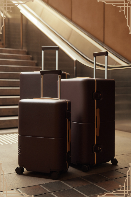 Two brown July Trunks at the foot of an escalator