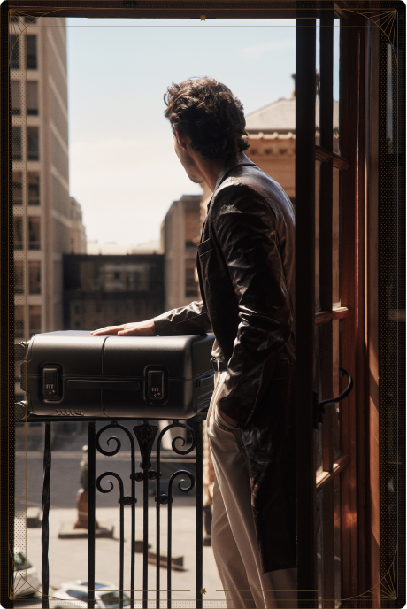 A man on a city balcony resting his hand on a July Trunk